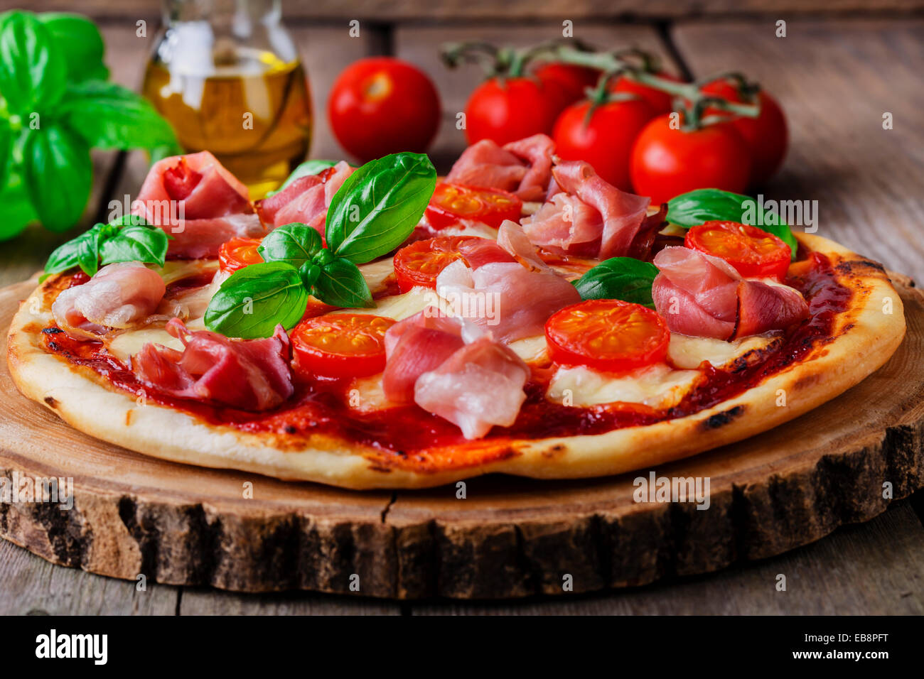 Pizza mit Tomaten, Mozzarella und Schinken Stockfoto