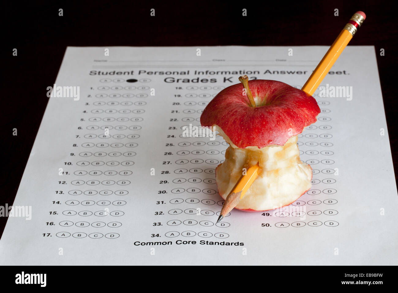 Ein Test-Blatt mit einem Apfel-Kern und einen Bleistift in ihm aufgespießt. Stockfoto