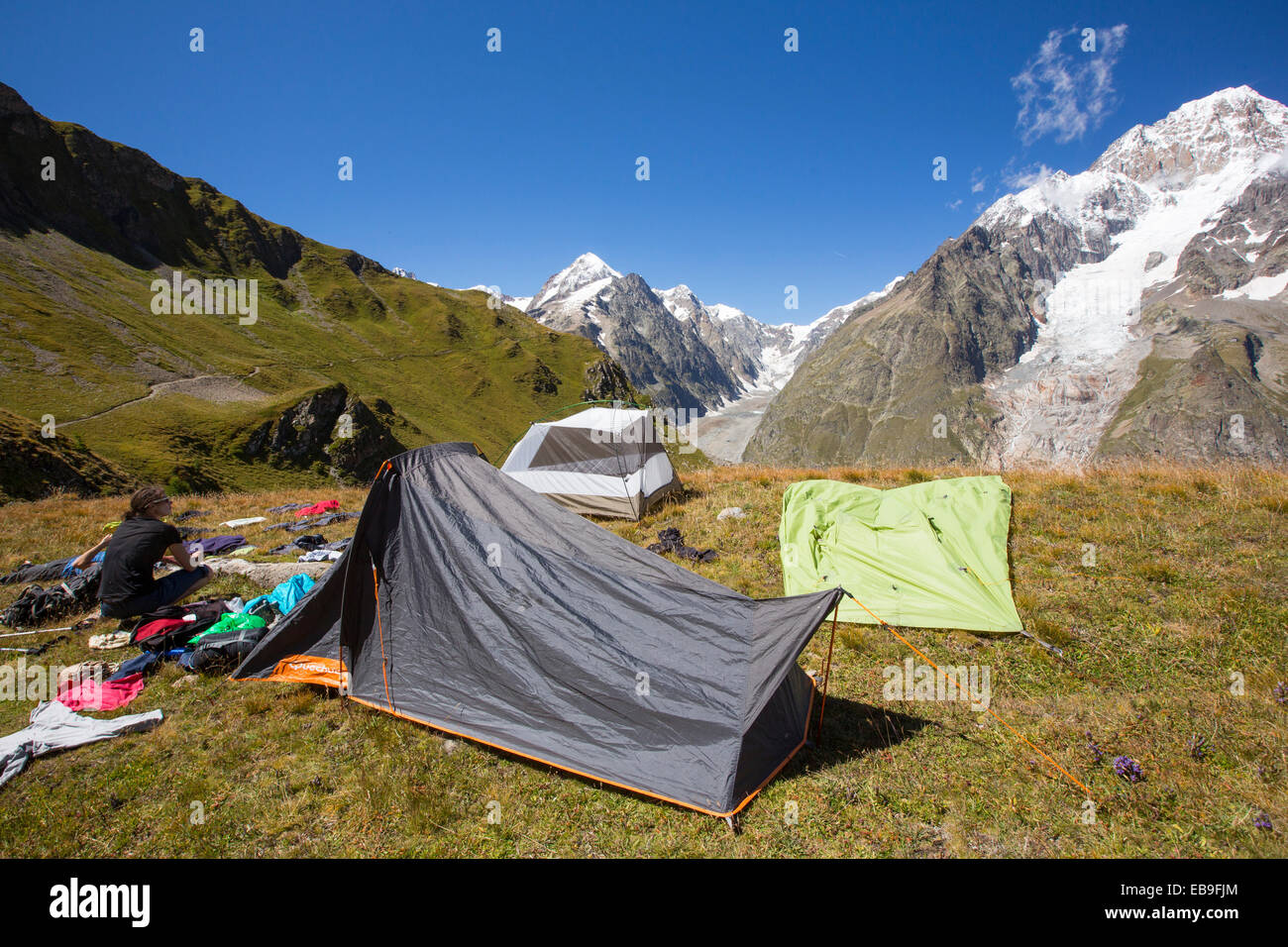 Wanderer auf die Tour de Mont Blanc ruhen und trocknen nasse Ausrüstung auf ihrem Campingplatz beim Aufstieg aus dem Vallon De La Lex Blanche in Italien unter Mont Blanc. Stockfoto
