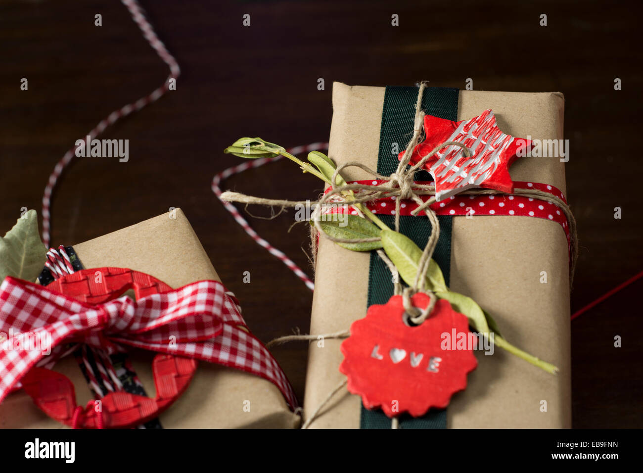 Weihnachtsgeschenke, Retro-Dekoration, Stars und roten Bändern, eingehüllt in Kraftpapier Stockfoto