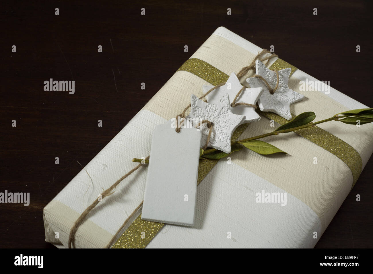 Geschenkbox mit handgefertigten, goldene Schleife und dekorativen weißen Sternen Stockfoto