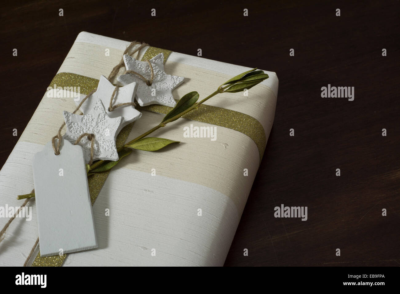 Geschenkbox mit handgefertigten, goldene Schleife und dekorativen weißen Sternen Stockfoto