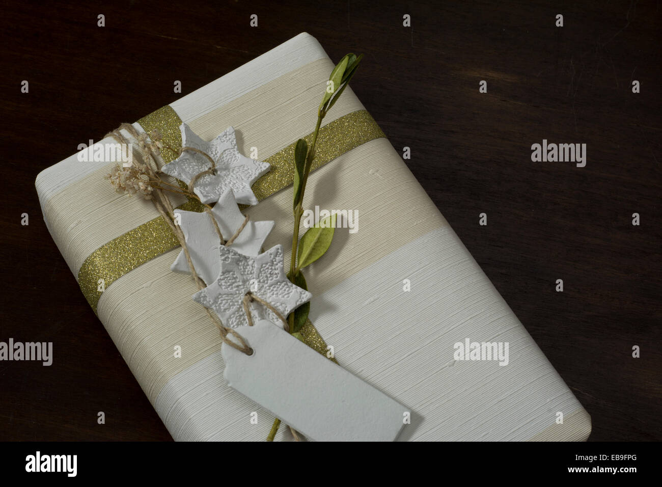 Geschenkbox mit handgefertigten, goldene Schleife und dekorativen weißen Sternen Stockfoto