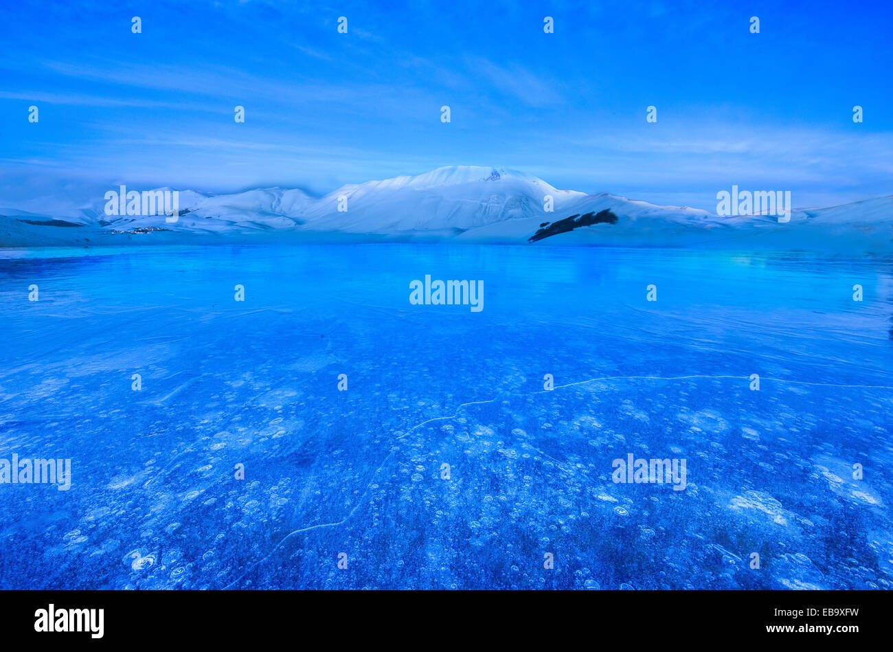 Monte Vettore zur blauen Stunde mit einer gefrorenen Pfütze mit Luftblasen, Nationalpark Monti Sibillini, Umbrien, Italien Stockfoto