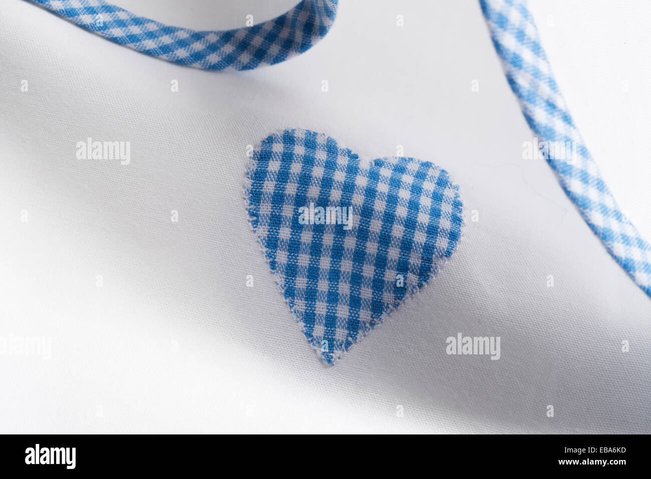 "Gingham" Applikation Herzen auf weißer Baumwolle Blattmaterial. Stockfoto