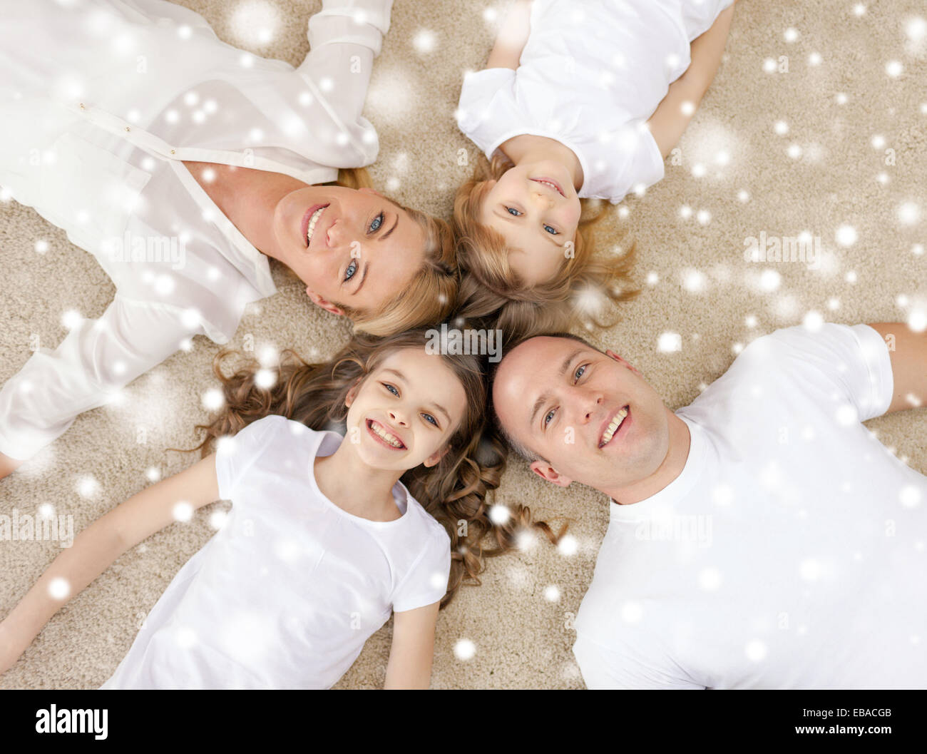 Eltern und zwei Mädchen auf Boden zu Hause Stockfoto