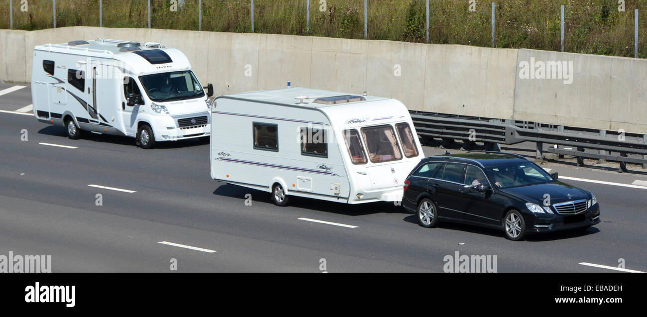 Zwei Sommerferien Transport Reise & Camping Optionen Auto schleppen weißen Wohnwagen Überholen Wohnmobil Wohnmobil Wohnmobil fahren entlang Autobahn England Großbritannien Stockfoto