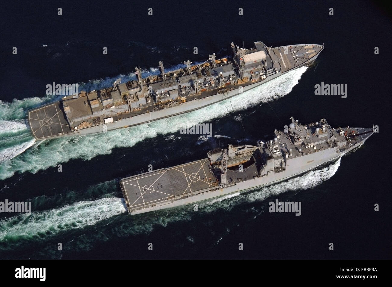 Das schnelle logistische Kampfunterstützung Schiff USNS liefern (T-AOE-6), links, führt eine im Gange Nachschub mit USS Comstock (LSD Stockfoto