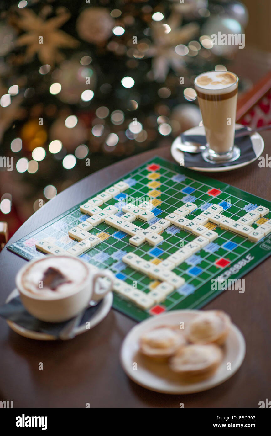 Scrabble Weihnachten Kreuzworträtsel festliche Worte mit Kaffee im Hintergrund und Vordergrund auslesen Stockfoto