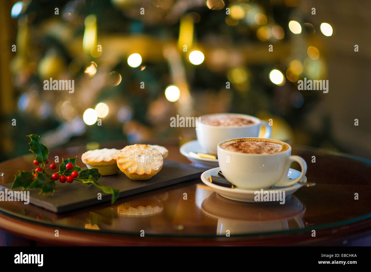 Mince Pies und Kaffee mit Holly vor Weihnachtsbaum Stockfoto