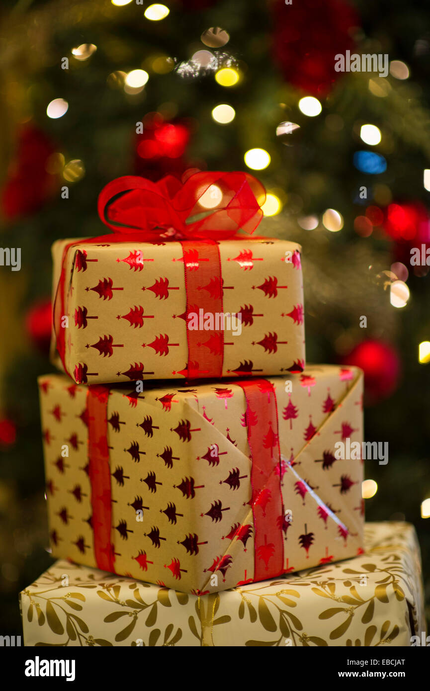 Weihnachtsgeschenke mit Weihnachtsbaum im Hintergrund unscharf Stockfoto