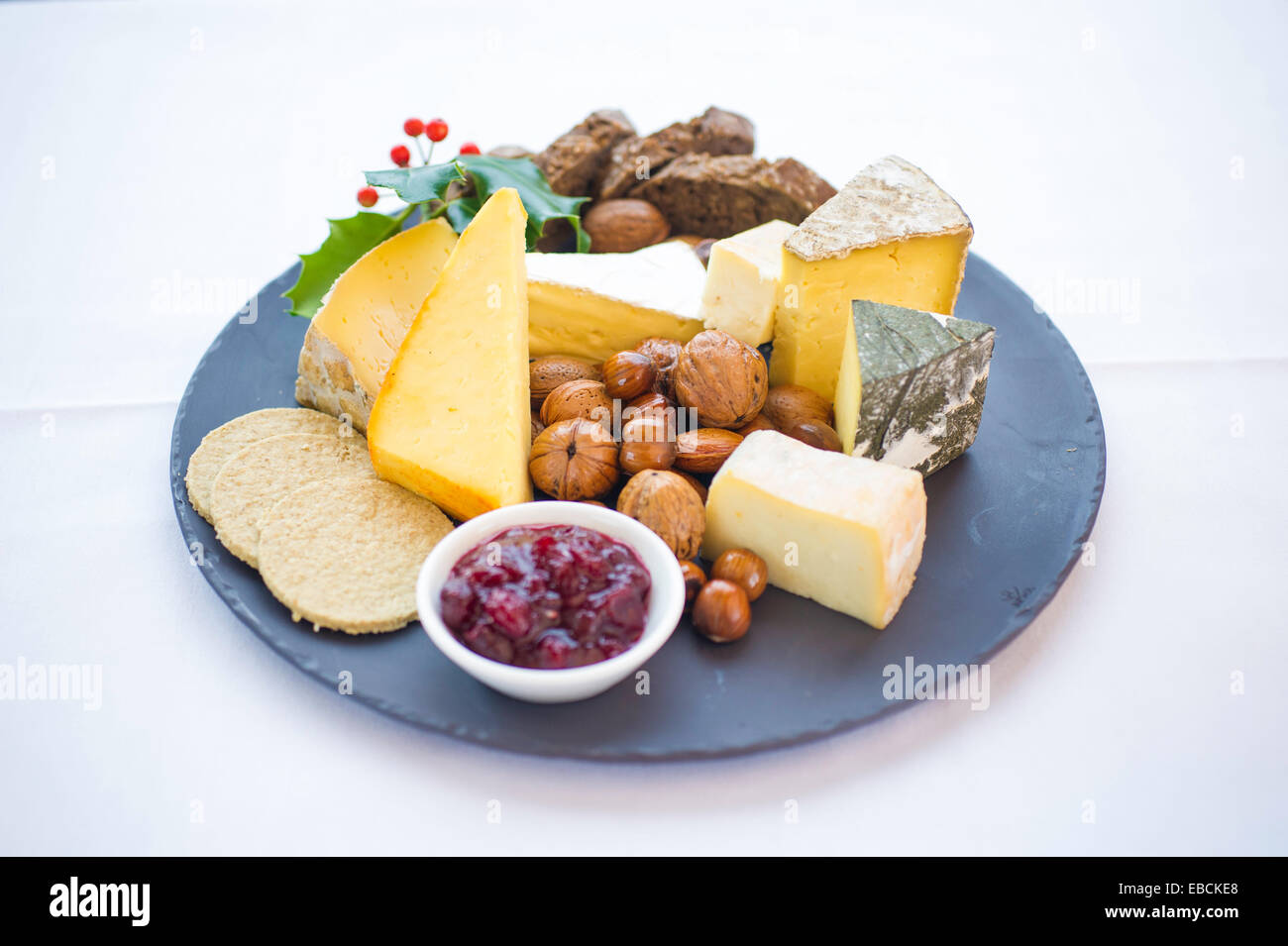 Auswahl an Weihnachten Käse auf einem Teller mit Holly. Stockfoto