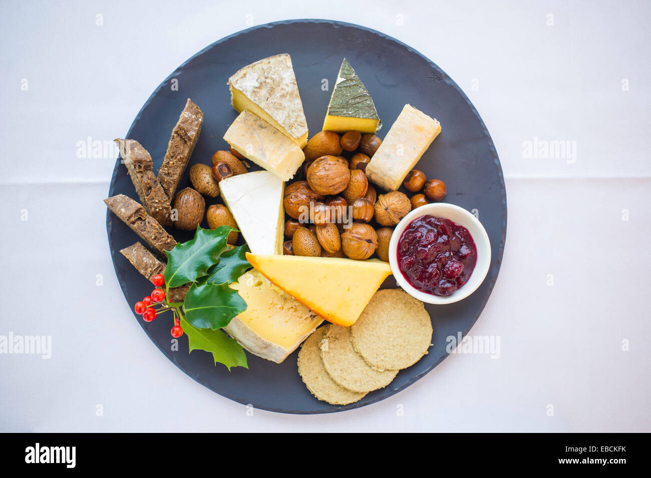 Auswahl an Weihnachten Käse auf einem Teller mit Holly. Stockfoto