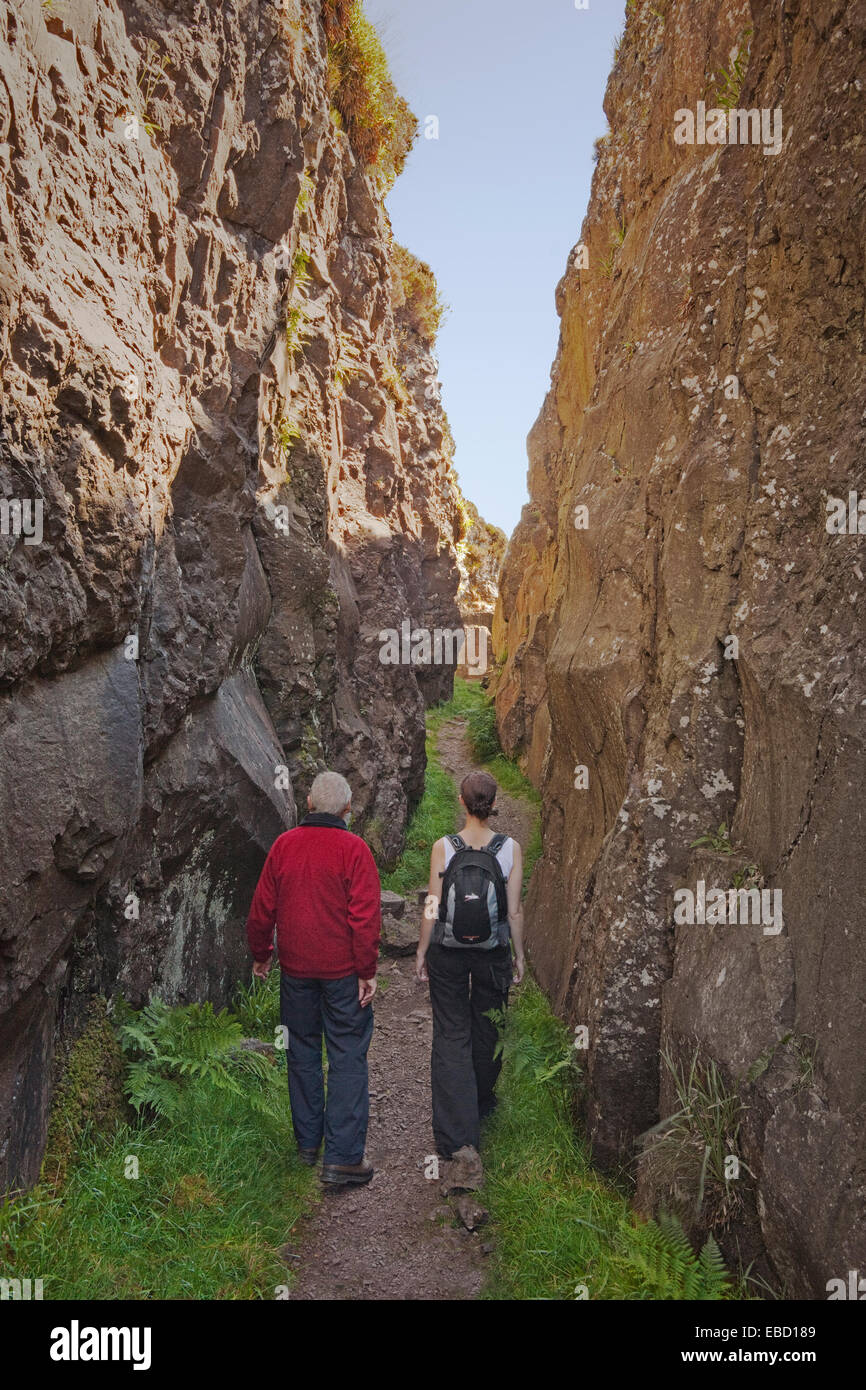 Zwei Wanderer in der Whangie-Rock-Funktion in der Kilpatrick Hills in der Nähe von Glasgow Stockfoto