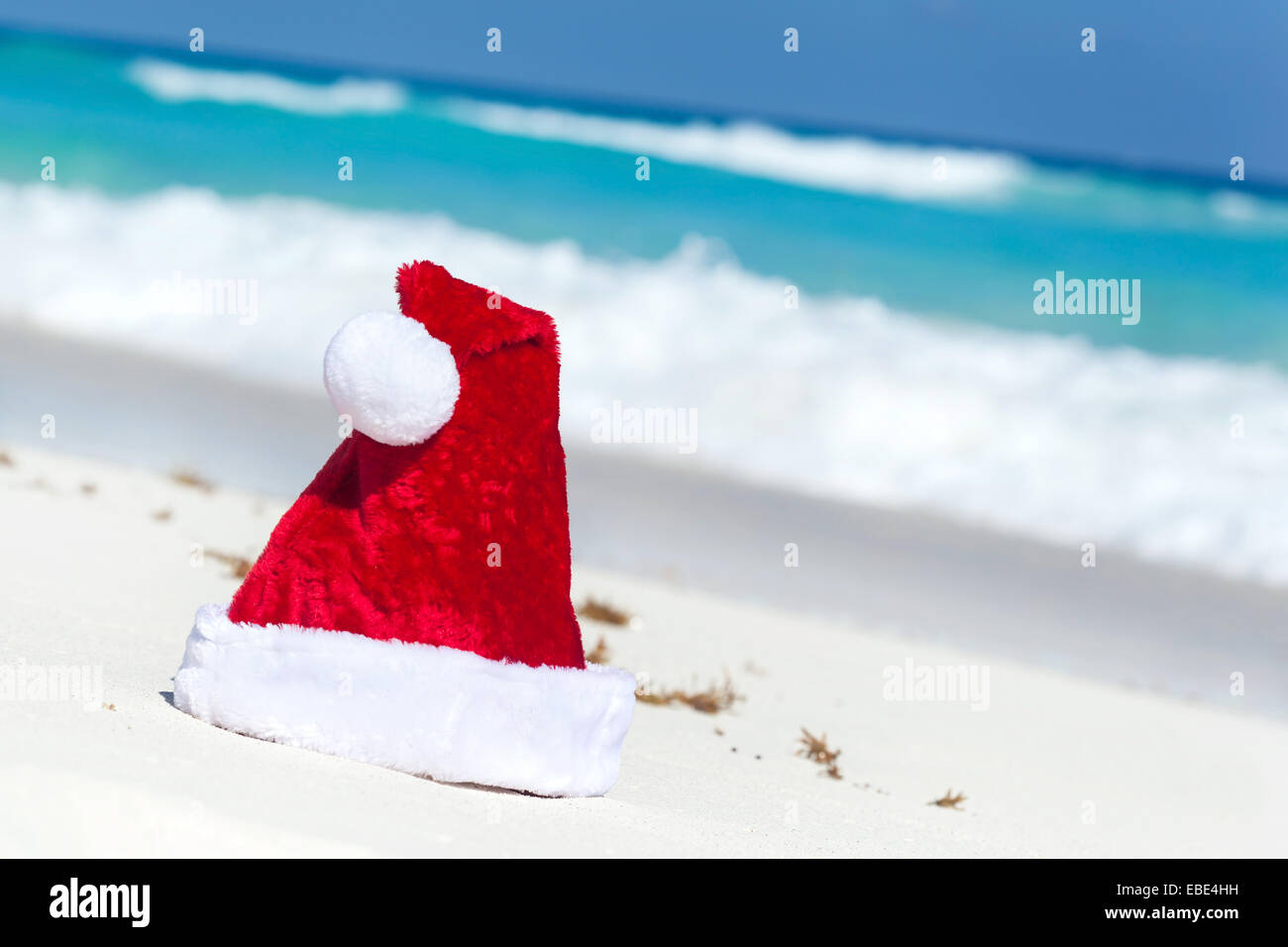 Weihnachtsmütze am weißen Sandstrand am karibischen Meer Hintergrund Stockfoto