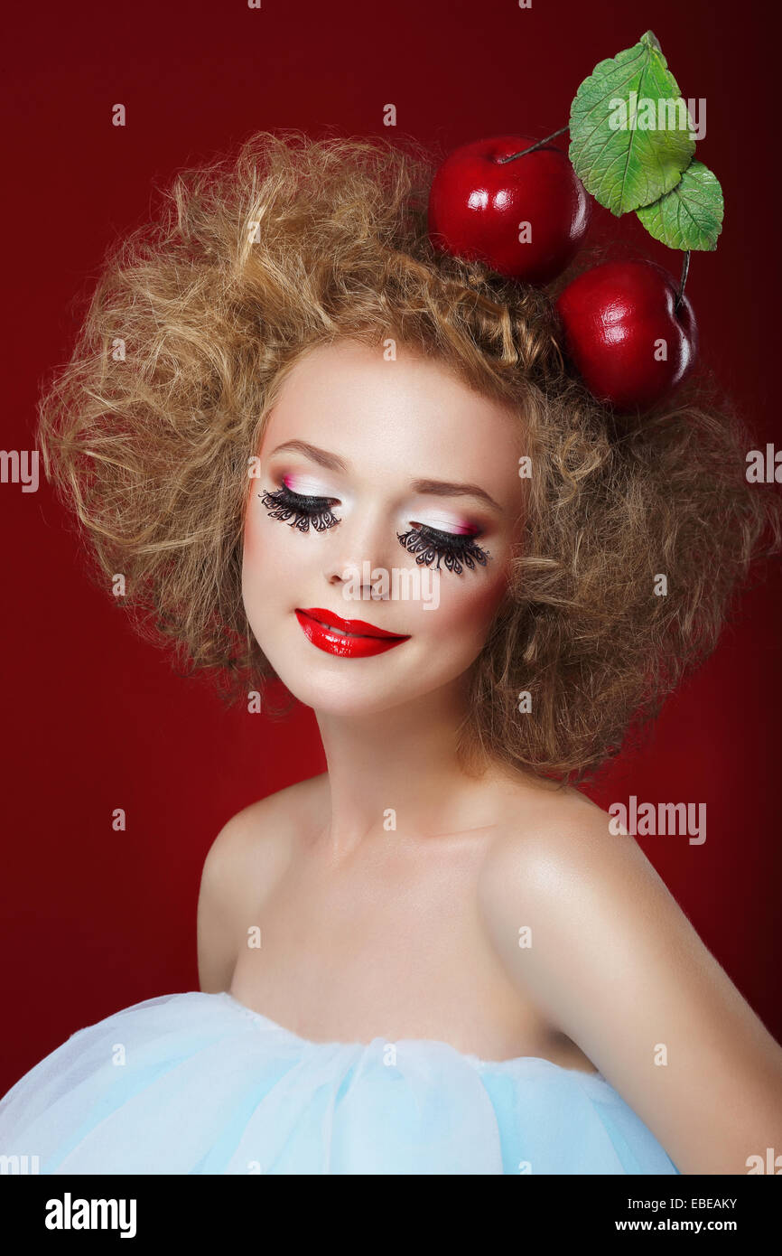 Groteske. Humorvolle Frau mit roten Äpfeln und Phantasie Make-up Stockfoto