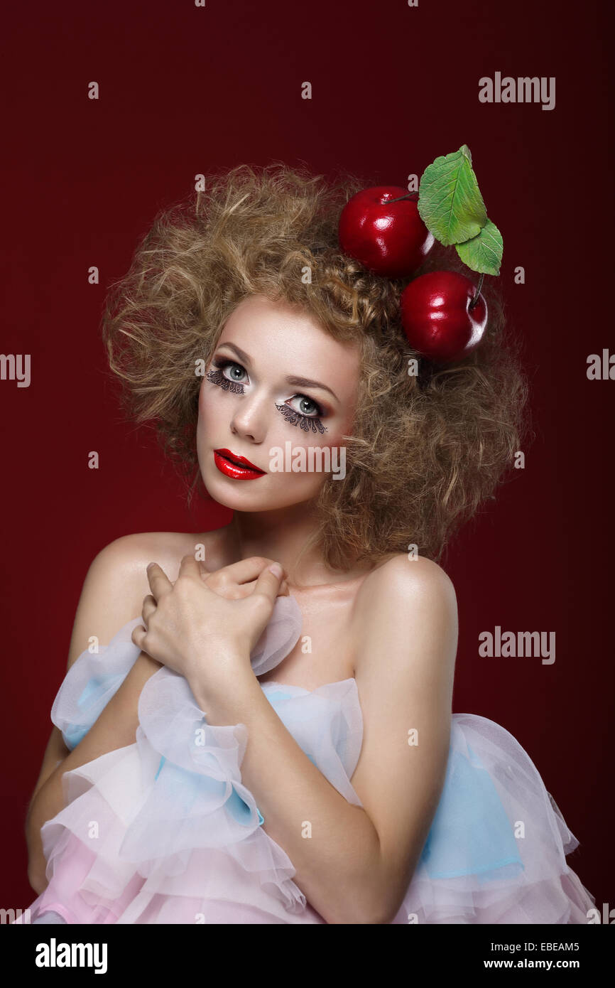 Kunstfertigkeit. Gestylte Frau mit zwei Äpfel auf dem Kopf Stockfoto