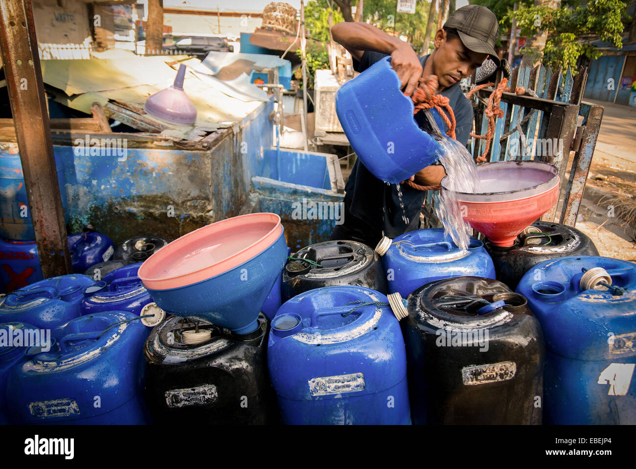 Ein mobiler Wasserversorger füllt Kanister auf dem Wagen bei einem Wasserversorger in Tanjung Priok, North Jakarta, Jakarta, Indonesien, mit Wasser. Stockfoto