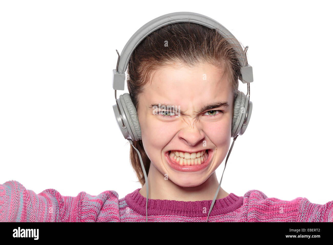 begeisterte Teenager-Mädchen mit Kopfhörern, isoliert auf weiss Stockfoto