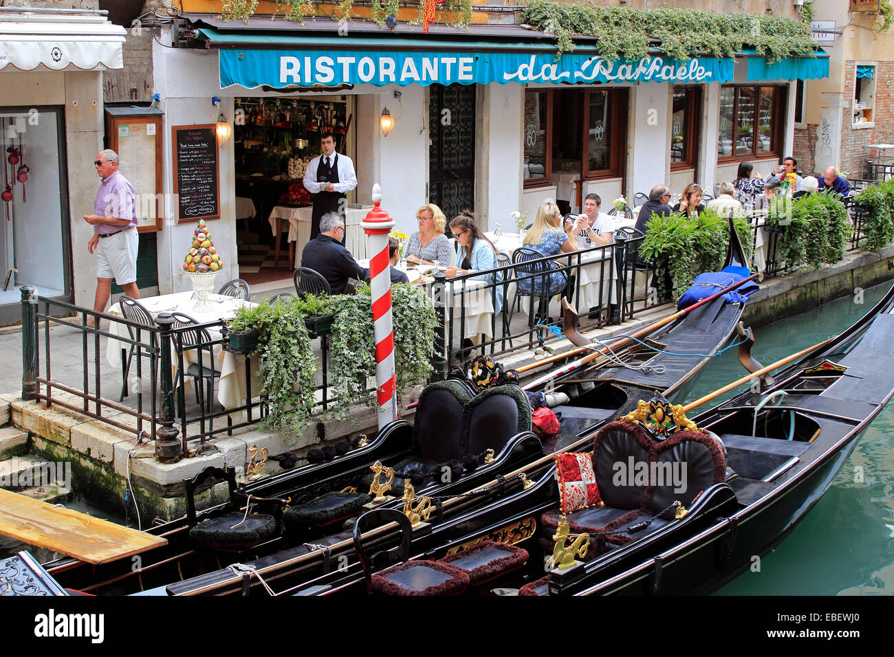 Venedig Sestiere San Marco Kellner dient Touristen an einem kleinen Kanal Stockfoto