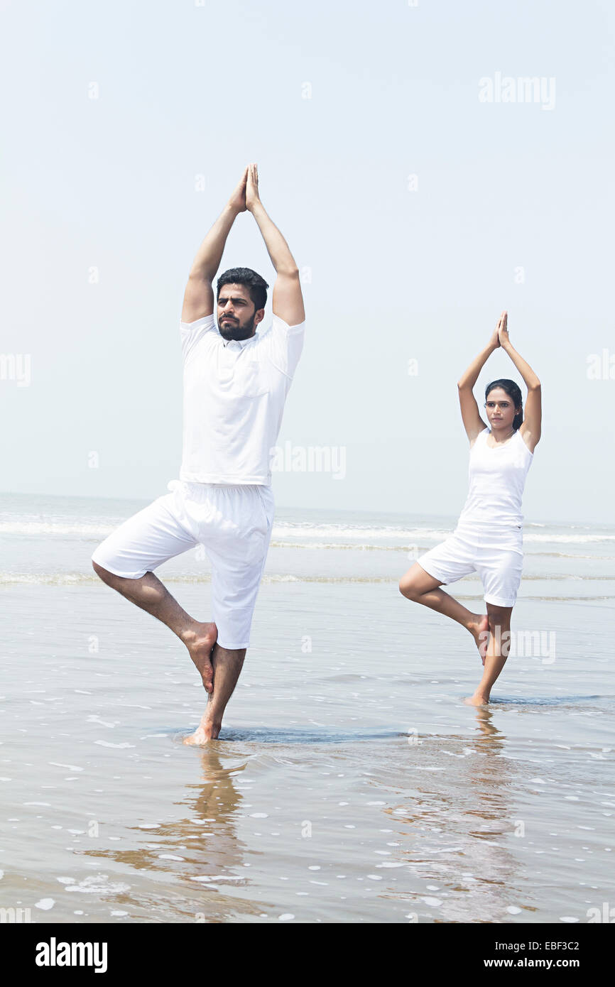 indische paar Strand Yoga Stockfoto