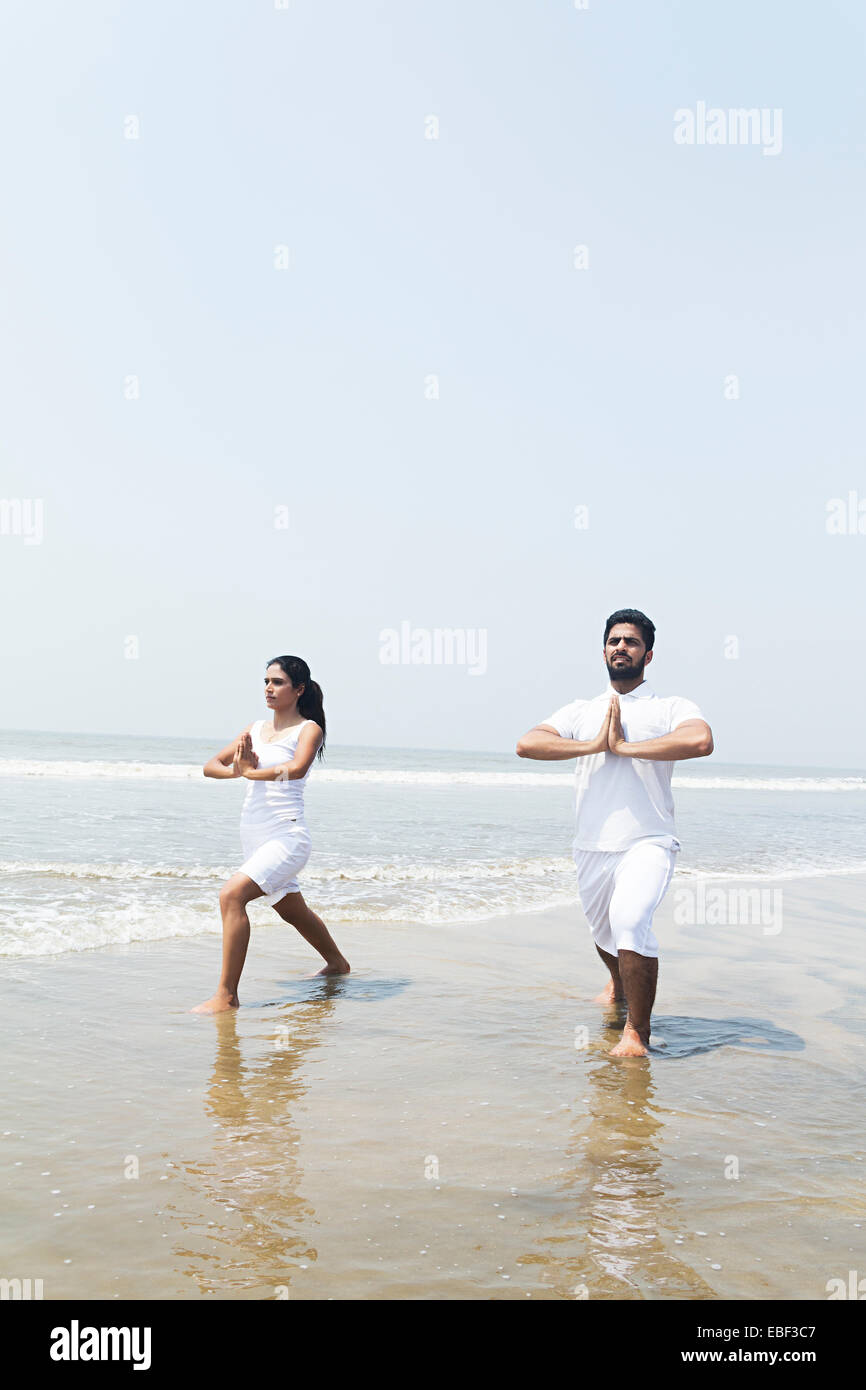indische paar Strand Yoga Stockfoto