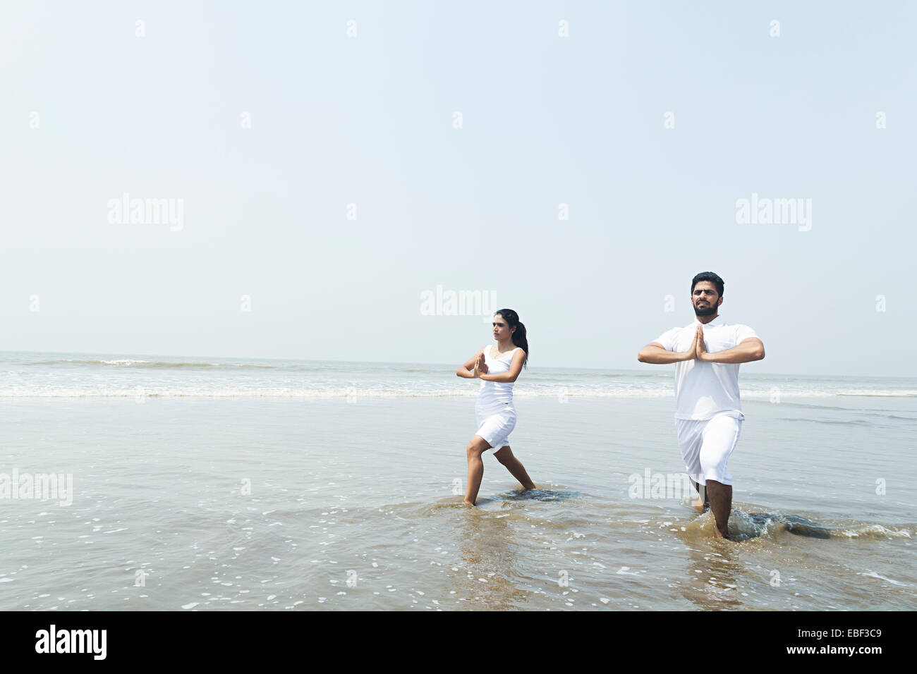 indische paar Strand Yoga Stockfoto