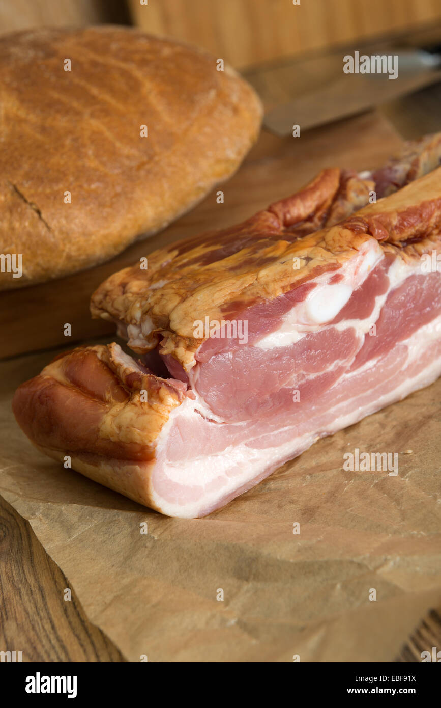 geräuchertem Schweinebauch - Speck und Brot auf dem Tisch Stockfoto