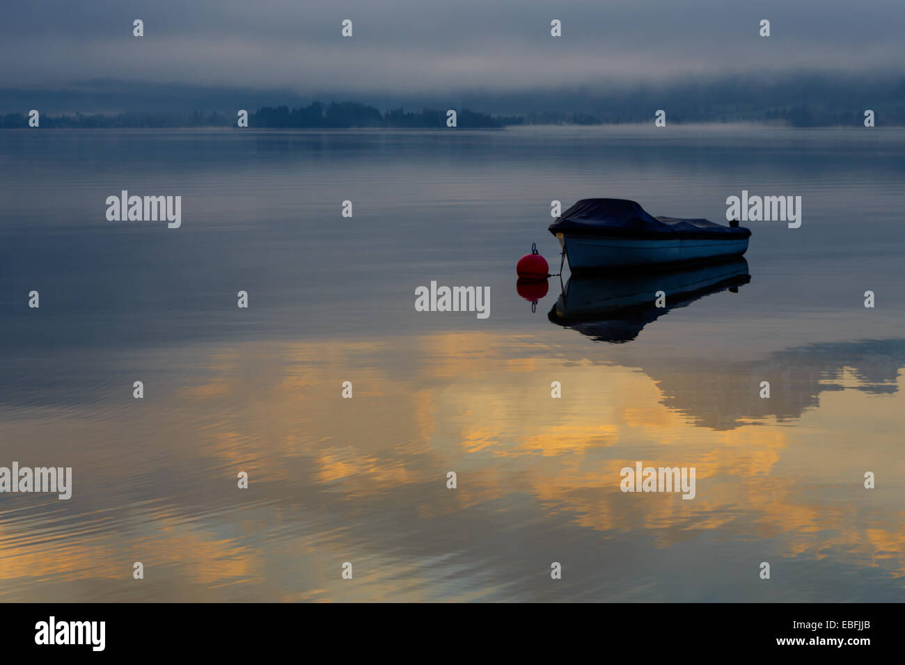 Einsames Boot auf einer Fläche von der See, Sonnenaufgang Stockfoto