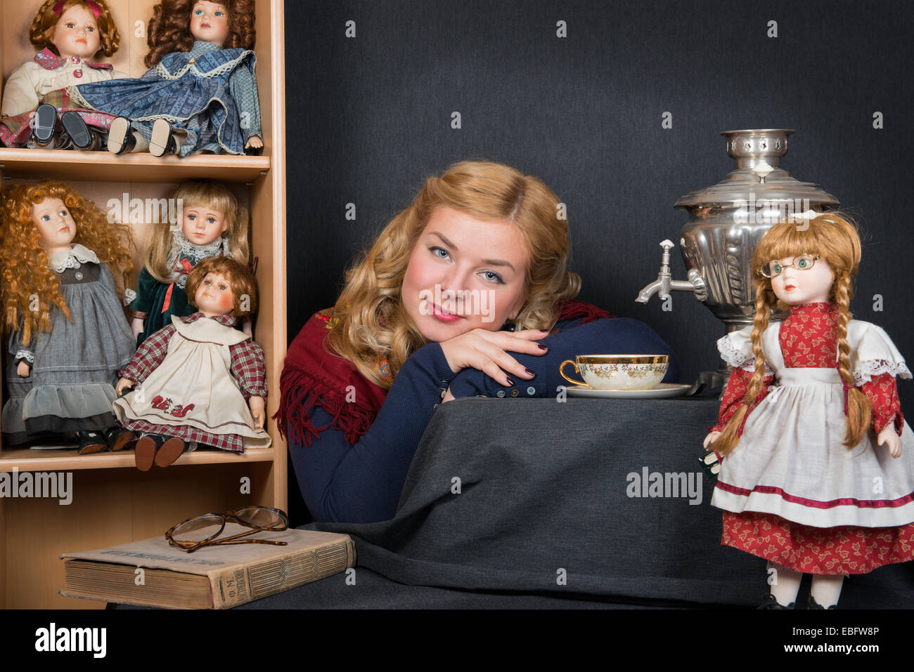 Ein blondes Mädchen mit ihren Puppen Teetrinken mit Samowar Stockfoto