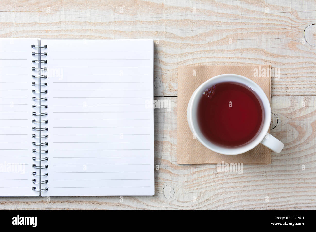 Nahaufnahme einer offenen Notebook und eine Tasse heißen Tee auf einem rustikalen weißer Holztisch. Hohen Winkel im Querformat gedreht. Stockfoto