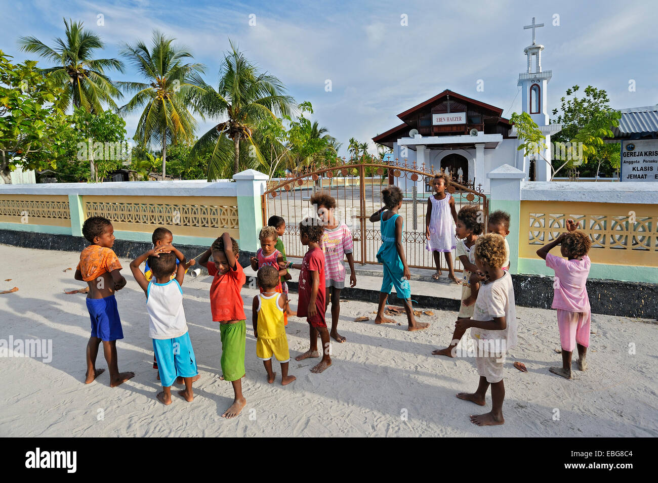 Eine Gruppe von Kindern steht man vor einer Kirche, Arborek, Raja Ampat, West Papua, Indonesien Stockfoto