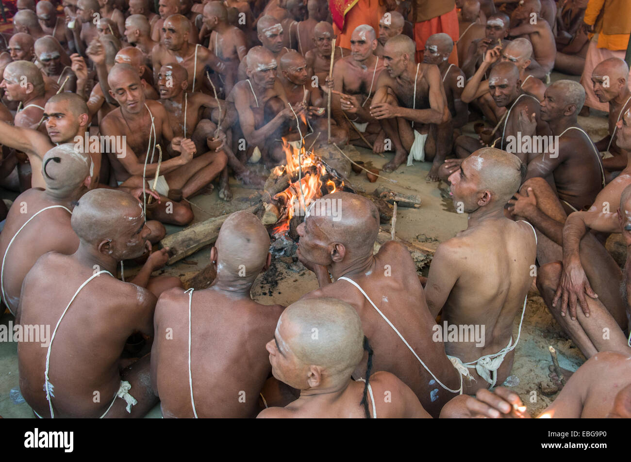 Um ein Lagerfeuer sitzen und singen von Mantras im Rahmen der Einleitung der neuen Sadhus, während Kumbha Mela Festival, Allahabad Stockfoto