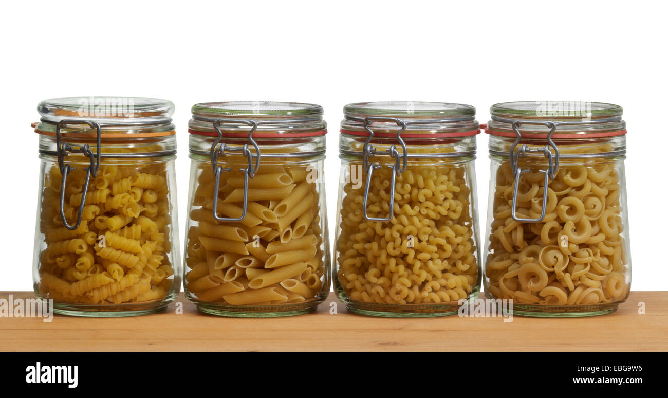 Holzbrett und einige konservierenden Flaschen aus Glas gefüllt mit italienischer Pasta-Nudeln Stockfoto