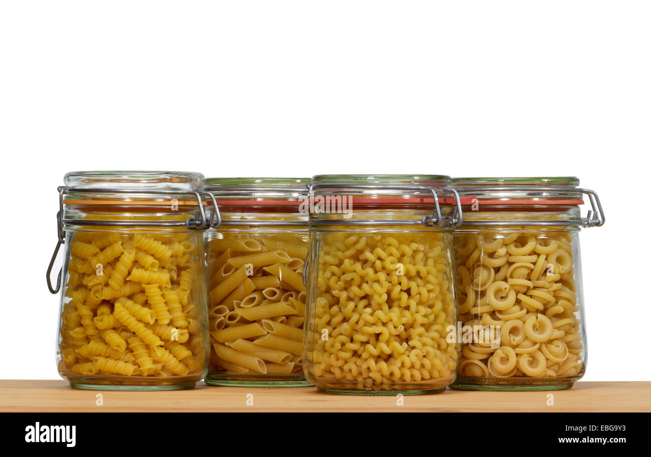 Holzbrett und einige konservierenden Flaschen aus Glas gefüllt mit italienischer Pasta-Nudeln Stockfoto