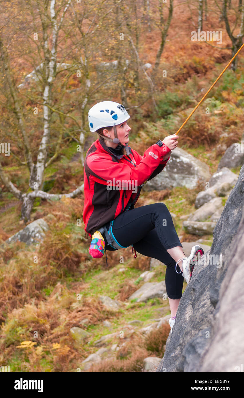 Junge Teenager-Mädchen wieder auf den Felsen klettern am birchenfarbig Rand in The Peak District von Derbyshire gesenkt Stockfoto