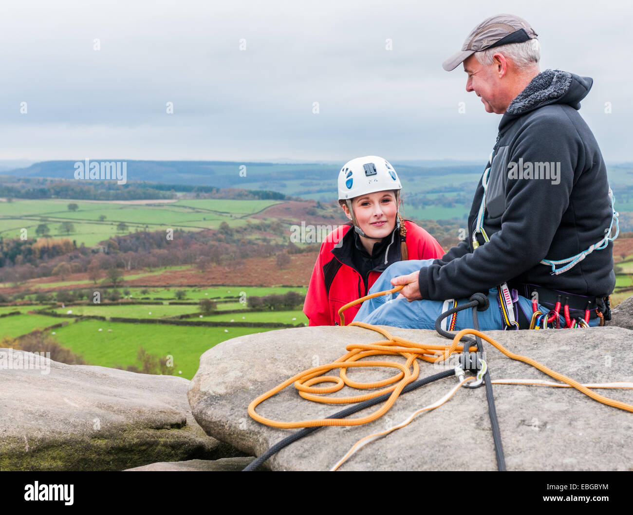 Teenager-Mädchen Kletterer am birchenfarbig Rand in The Peak District von Derbyshire kommen an die Spitze der Steigung mit ihrem Lehrer Stockfoto