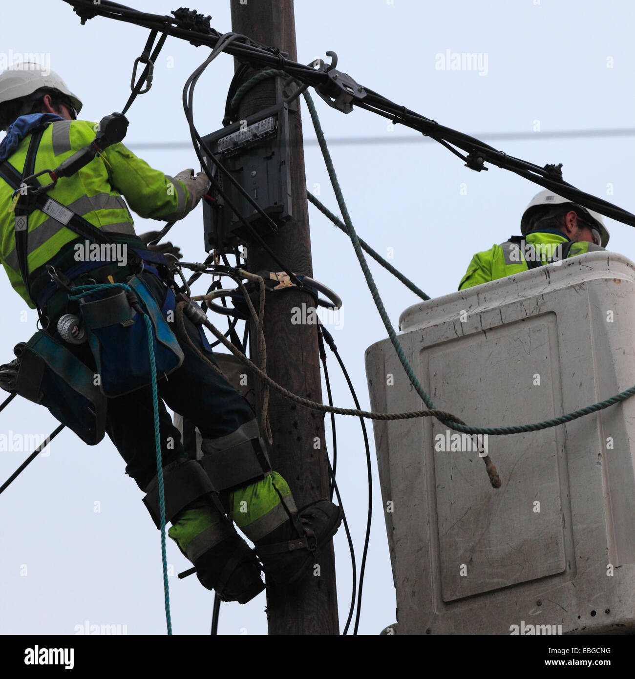 Zwei macht Versorgungsmaterial Arbeiter elektrische Kabel zu ersetzen. Stockfoto