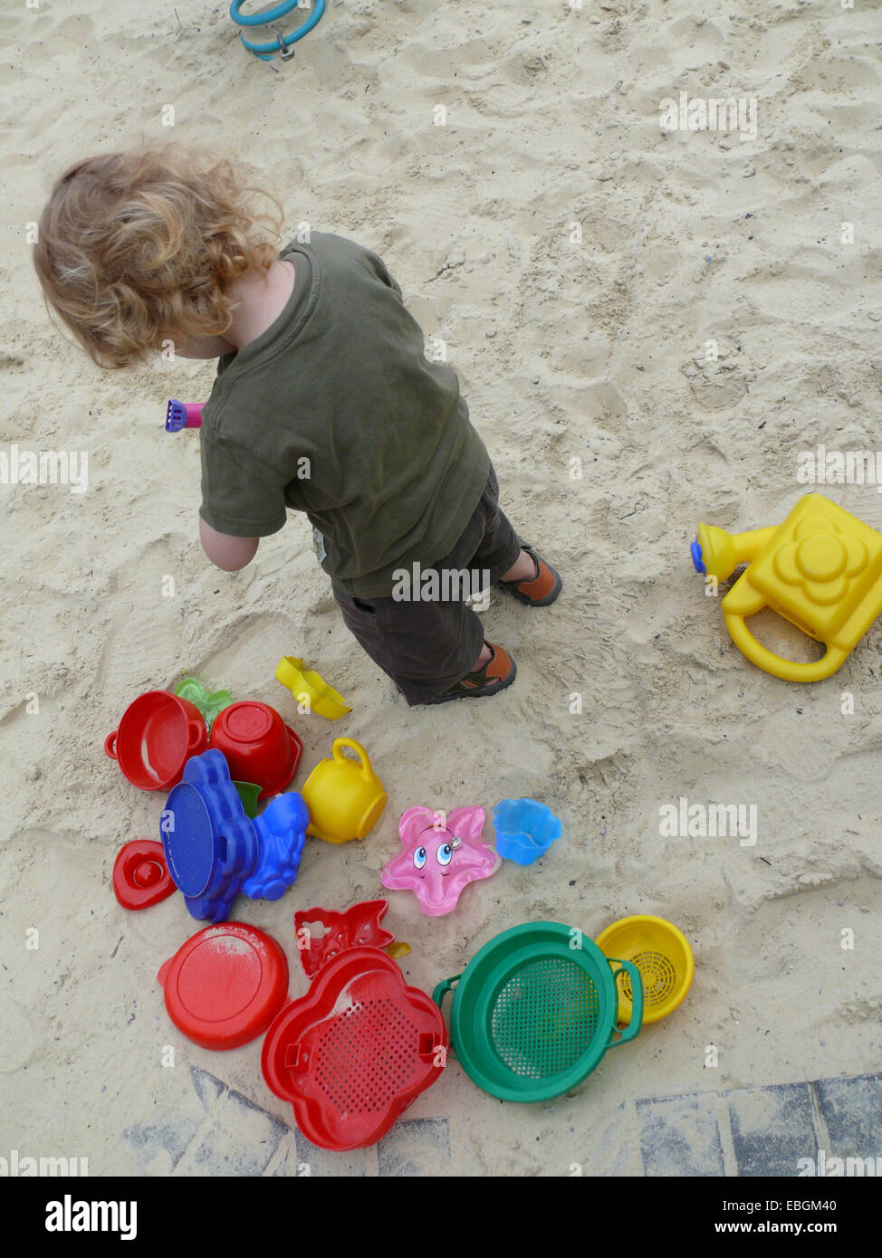 kleiner Junge auf dem Spielplatz mit Sandformen Stockfoto