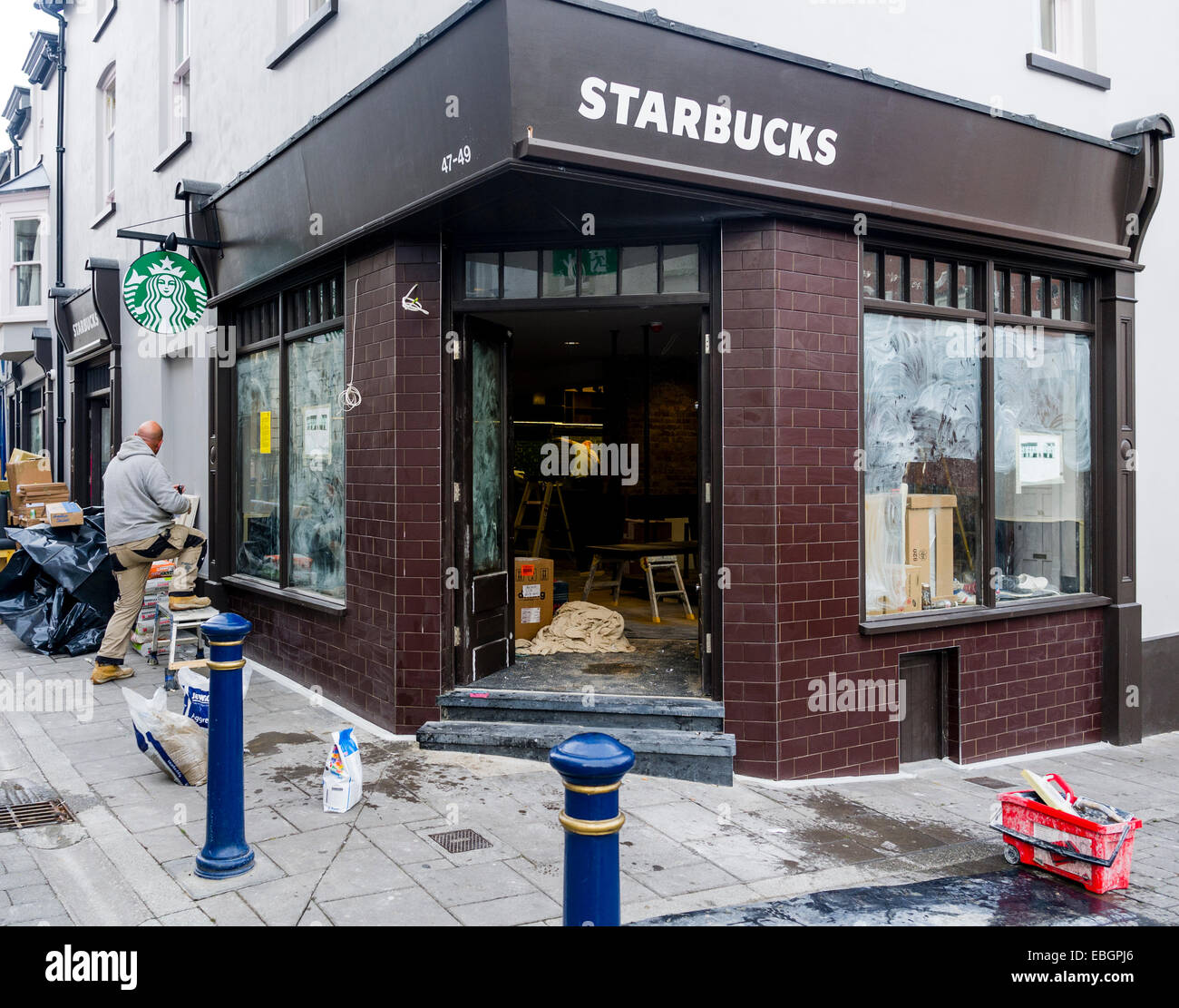 Außen: Arbeitnehmer, die Einrichtung einer neuen Niederlassung von Starbucks Café Café Franchise Aberystwyth UK Stockfoto