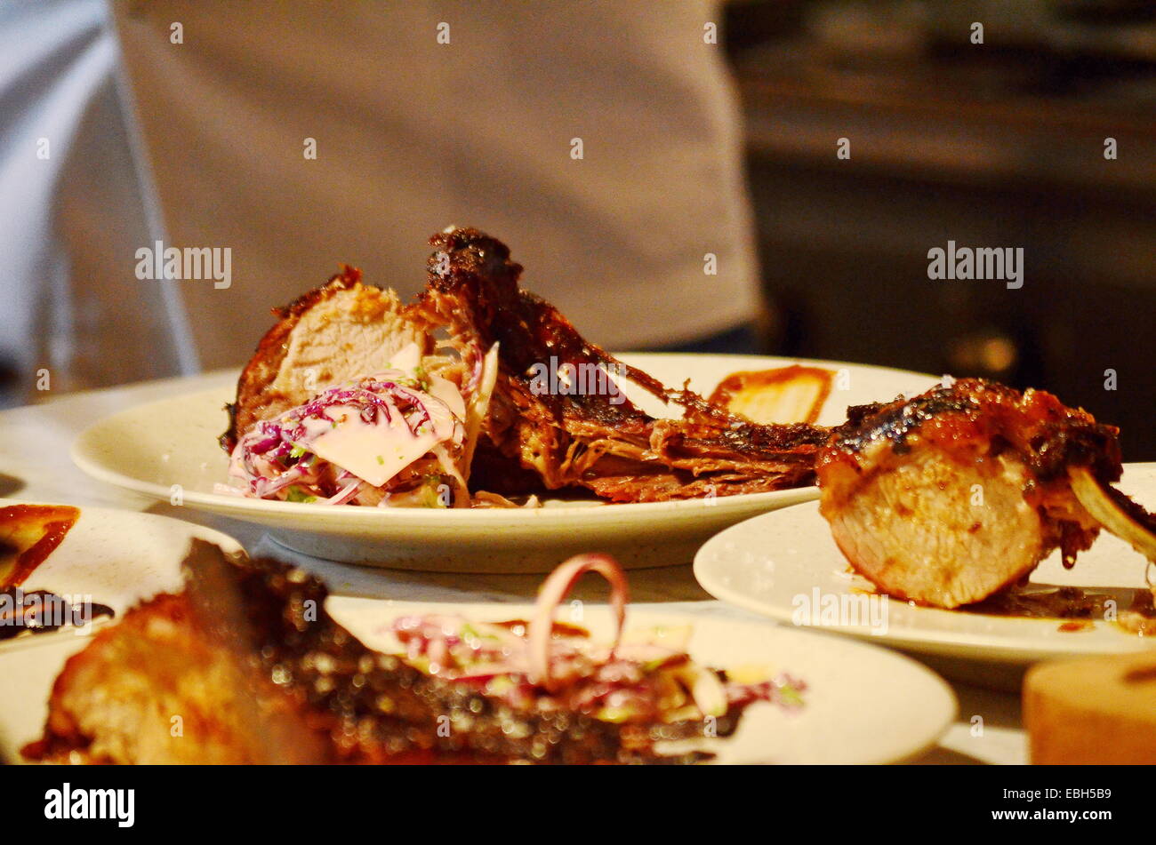 Portionen von Wildschweinen mit Barbecue-Sauce und Salat Stockfoto