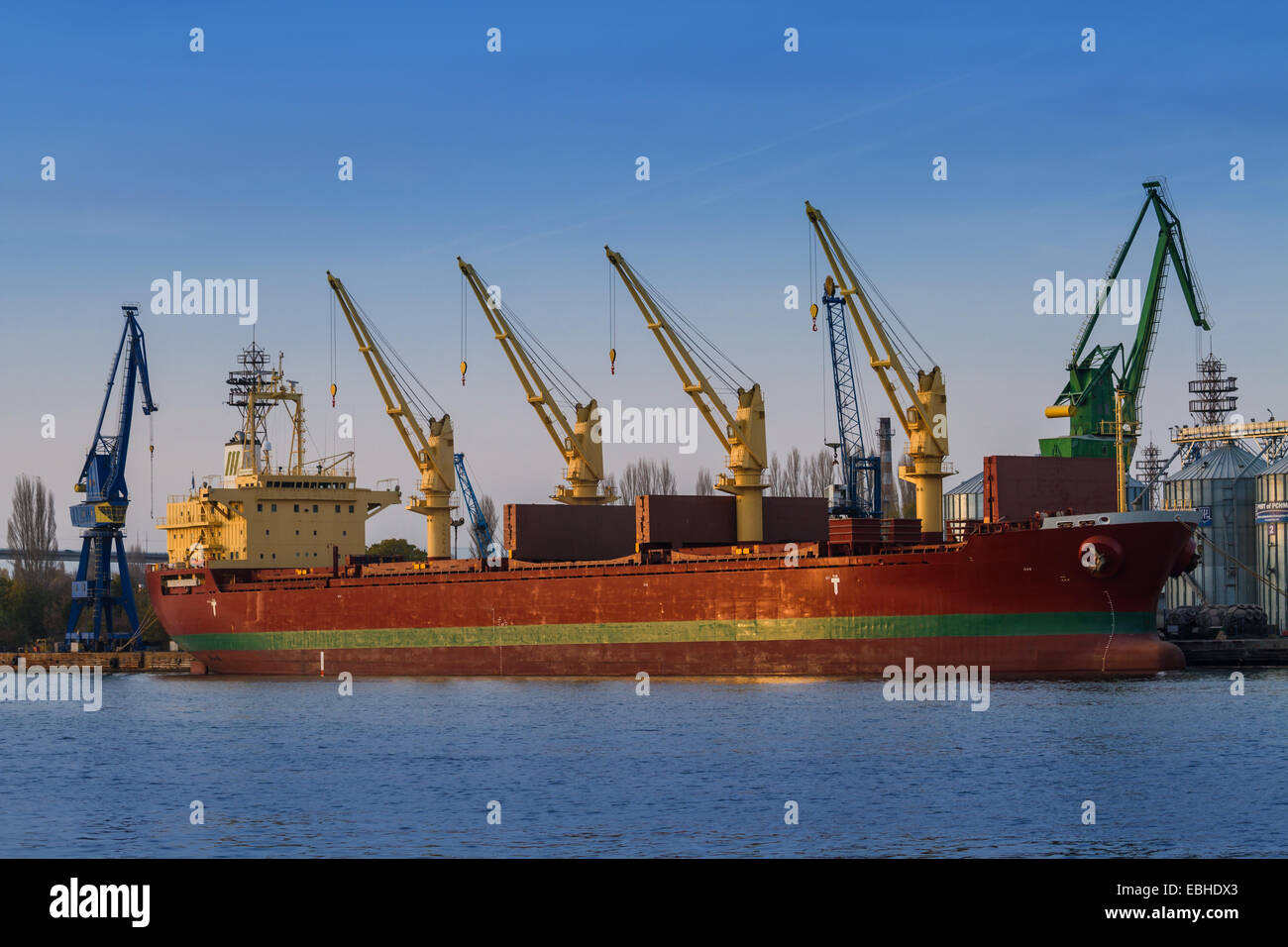 Industrie-Container Cargo Fracht Versenden mit Kranbrücke in Werft in der Abenddämmerung für Logistik Import/Export Hintergrund arbeiten Stockfoto