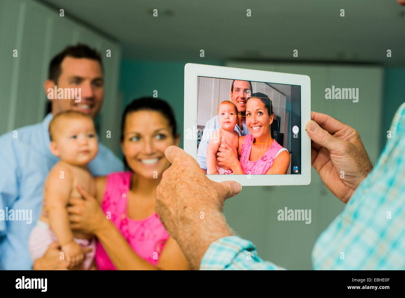 Über Schulter Porträt der Mitte erwachsenes paar und Tochter auf digital-Tablette genommen Stockfoto