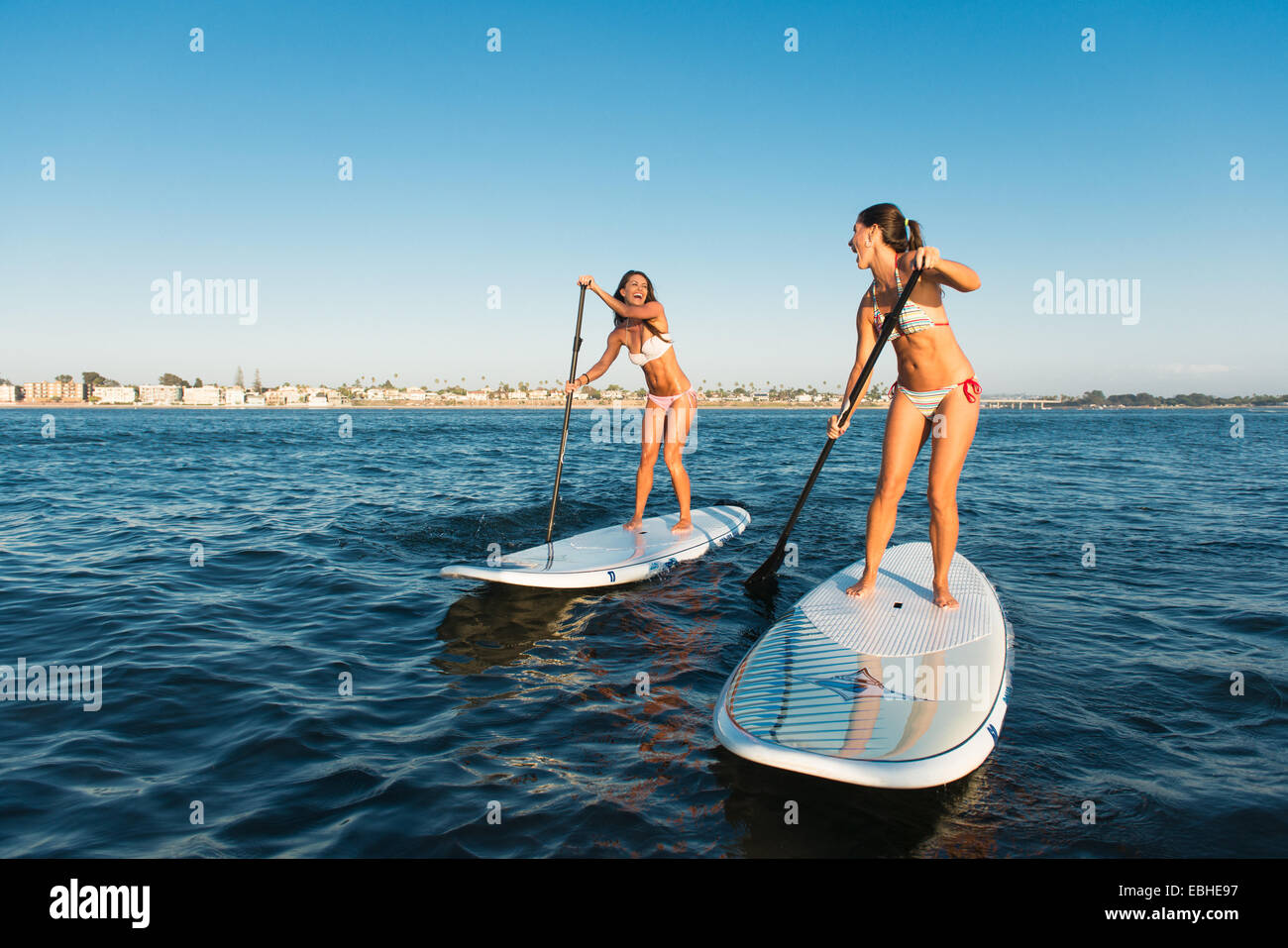 Zwei Frauen im Chat während aufstehen Paddling, Mission Bay, San Diego, Kalifornien, USA Stockfoto