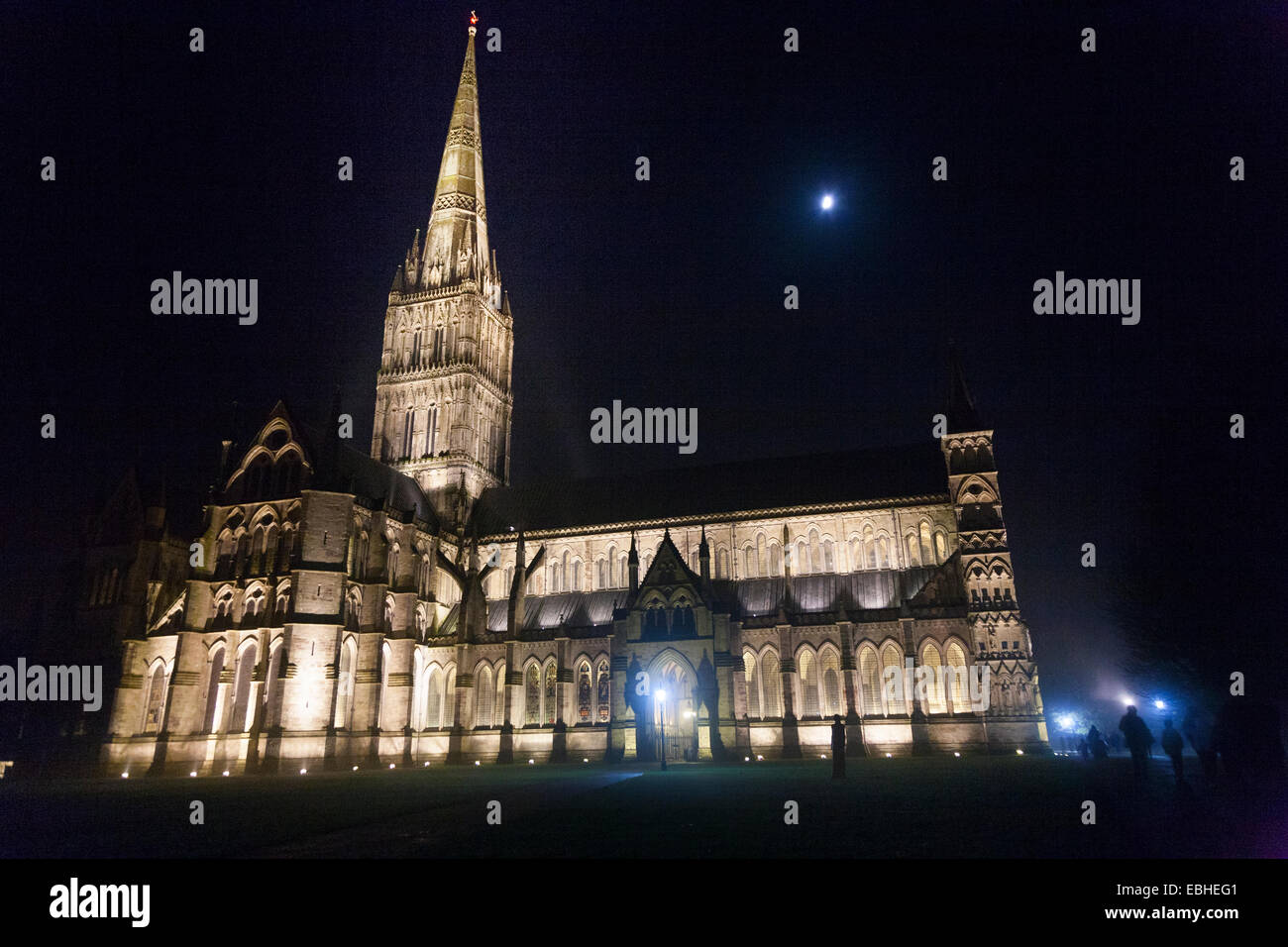 Kathedrale von Salisbury in Dunkelheit mit Flutlicht / Dunkelheit in der Nacht in der Nacht mit Mond, während der Herbst / Winter. Salisbury. UK Stockfoto