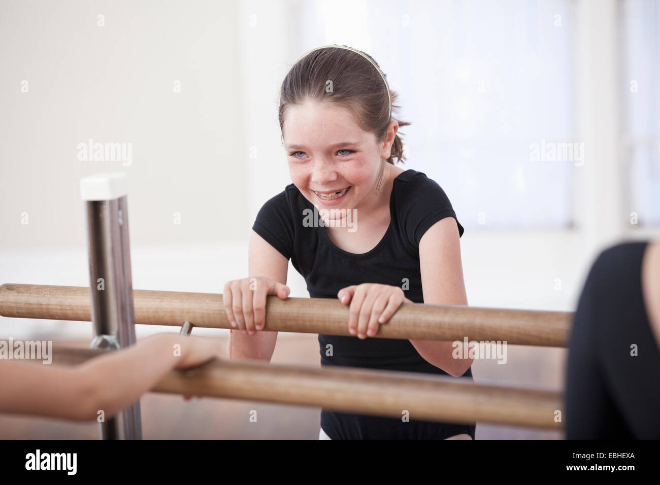 Mädchen lacht während der Barre in der Ballettschule Stockfoto