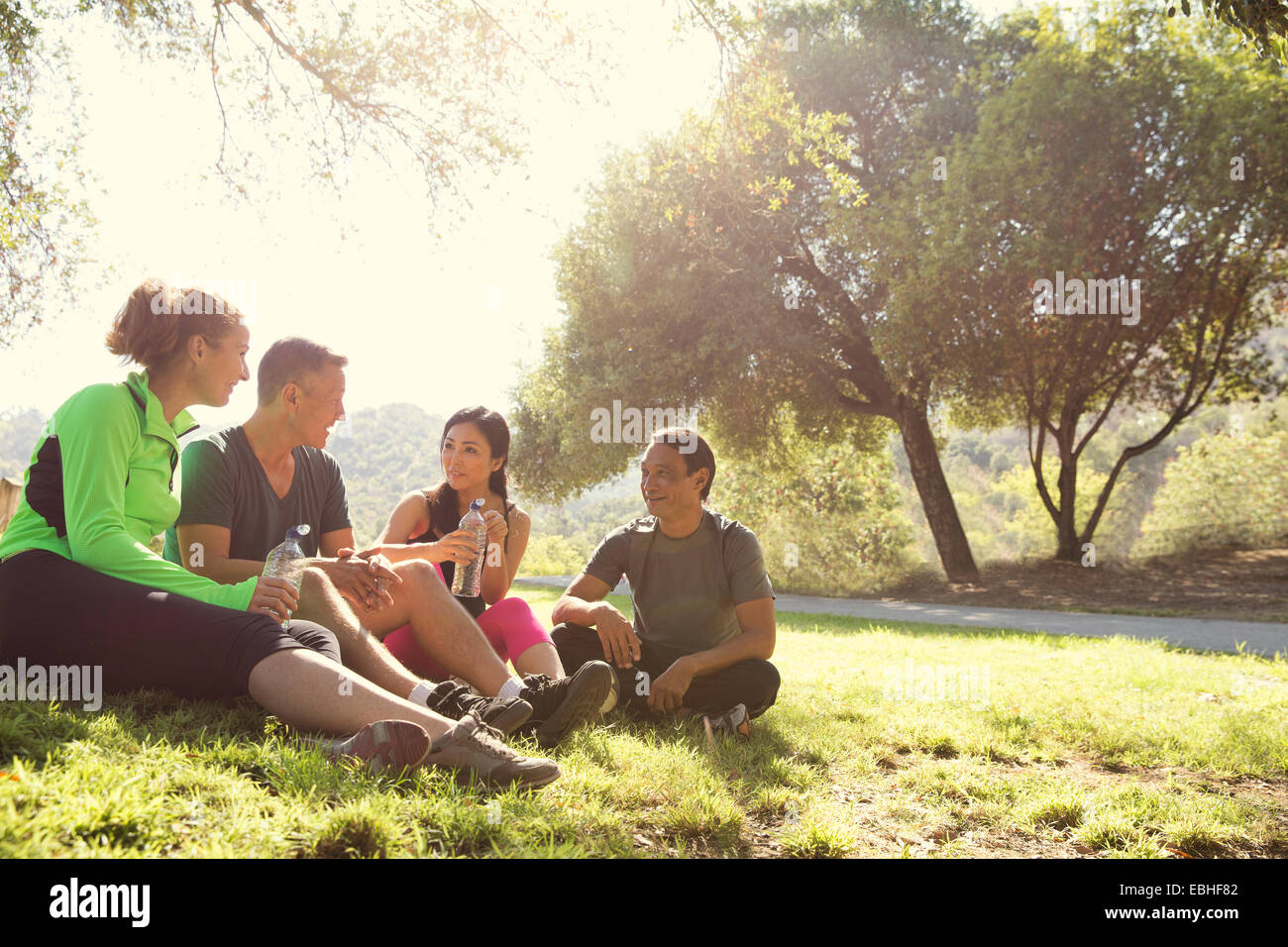 Vier Reifen männlichen und weiblichen Läufer sitzen im Chat im Park Stockfoto