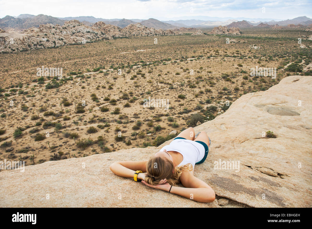 Frau macht Pause auf Berg, Joshua Tree Nationalpark, Kalifornien, USA Stockfoto