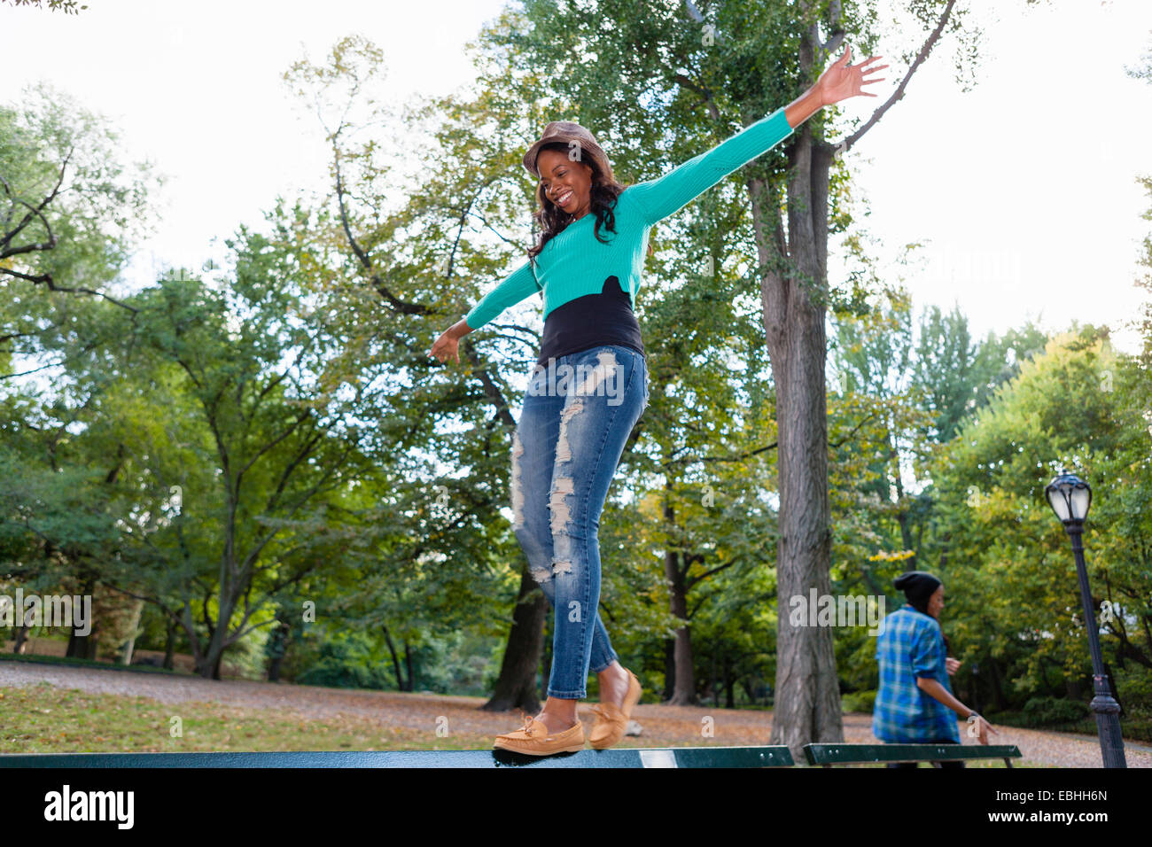 Frau balancieren auf Geländer im park Stockfoto