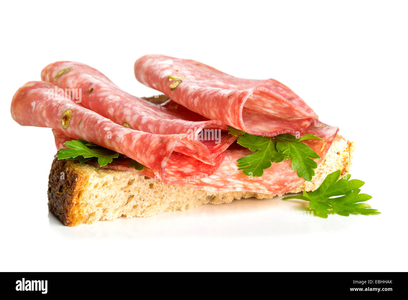 Sandwich mit Salami Wurst und Petersilie auf weißem Hintergrund Stockfoto